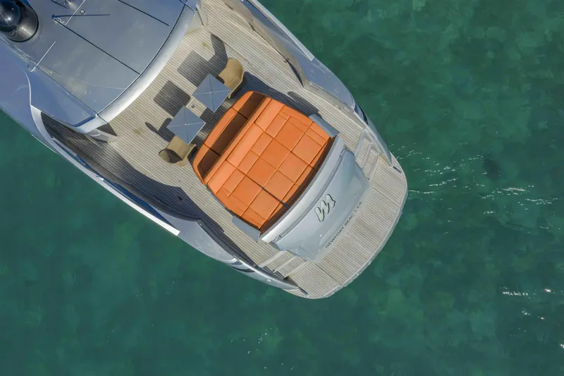M Yacht Photos Pics Aerial view of 2018 Pershing 70 yacht with sunbathing area on turquoise water.