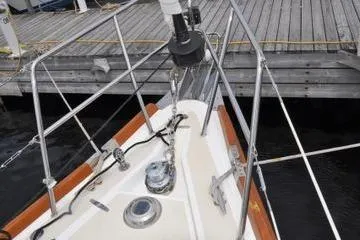 Dragonfly 1 Yacht Photos Pics Bow of a 2005 Tartan 4400 sailboat docked at a wooden pier.
