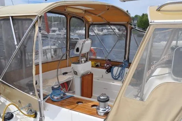 Dragonfly 1 Yacht Photos Pics 2005 Tartan 4400 sailboat cockpit with beige canopy and marina background.