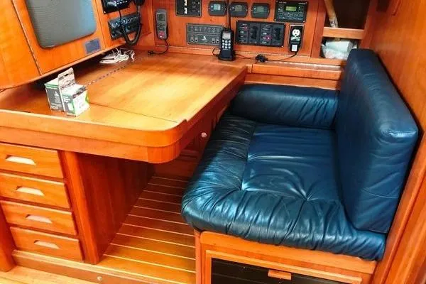 Dragonfly 1 Yacht Photos Pics 2005 Tartan 4400 yacht interior with navigation station and blue cushioned seating.