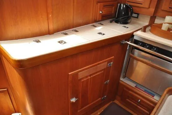 Dragonfly 1 Yacht Photos Pics 2005 Tartan 4400 yacht interior with wooden cabinetry and modern kitchen amenities.
