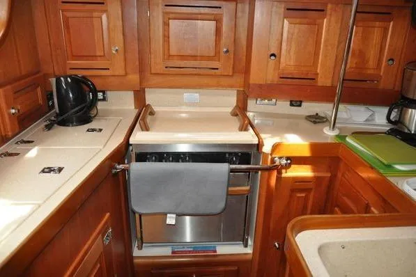 Dragonfly 1 Yacht Photos Pics 2005 Tartan 4400 yacht kitchen with wooden cabinetry and modern appliances.