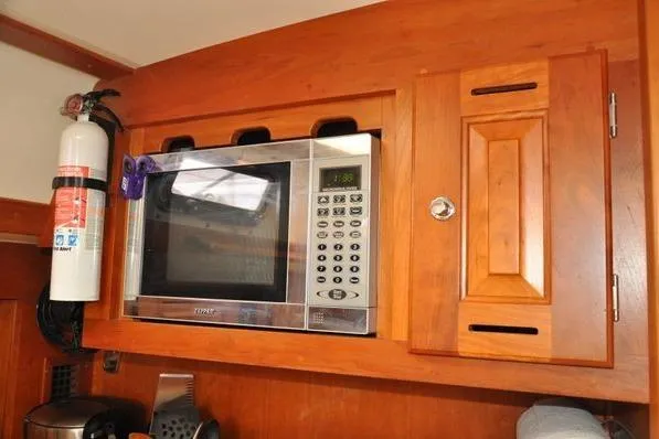 Dragonfly 1 Yacht Photos Pics Built-in microwave in wooden cabinet on 2005 Tartan 4400 yacht kitchen.