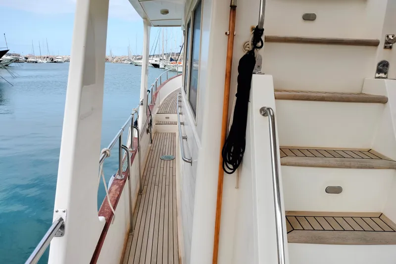 Sesaccia Yacht Photos Pics 2007 Grand Banks 47 Europa yacht deck with wooden stairs and railing, docked at marina.