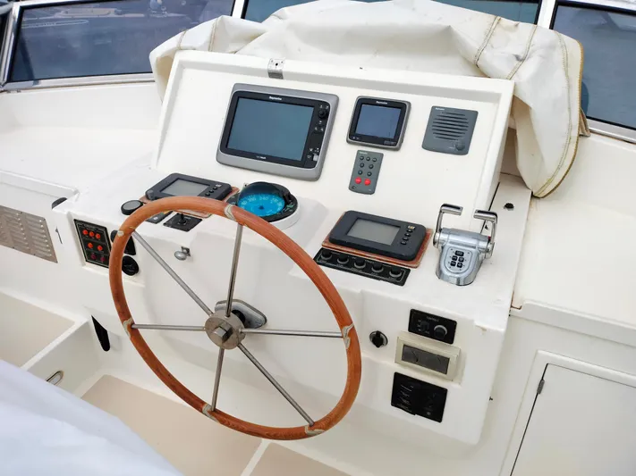 Sesaccia Yacht Photos Pics Helm of 2007 Grand Banks 47 Europa yacht with navigation instruments and wooden steering wheel.