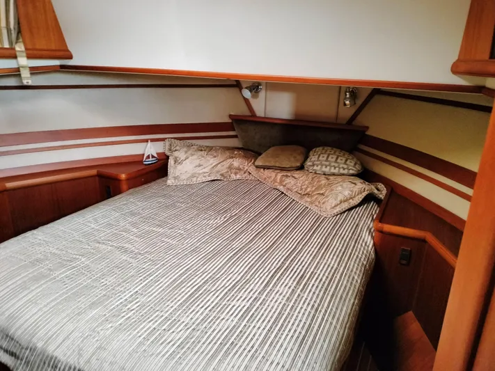 Sesaccia Yacht Photos Pics Cozy bedroom in 2007 Grand Banks 47 Europa yacht with striped bedding and wooden accents.