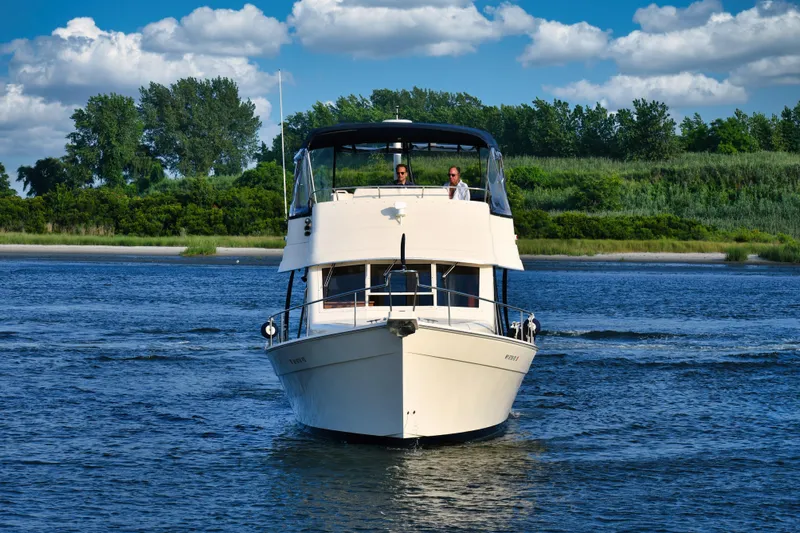  Yacht Photos Pics 2008 Mainship 34 Trawler cruising on a scenic river with lush greenery.