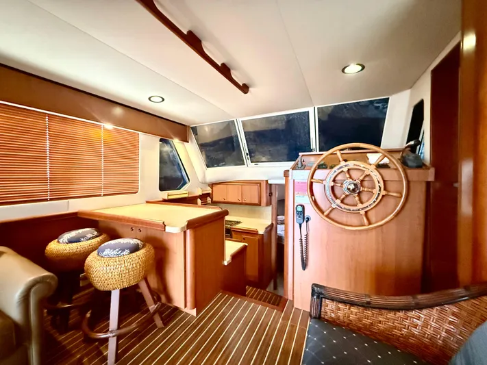  Yacht Photos Pics Interior of 2008 Mainship 34 Trawler with wooden helm, seating, and nautical decor.