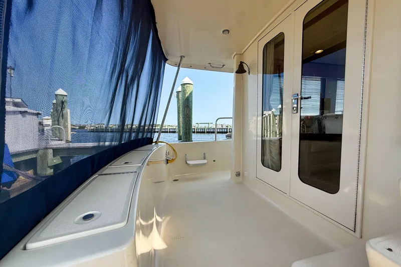  Yacht Photos Pics 2008 Mainship 34 Trawler deck with blue canopy and marina view.