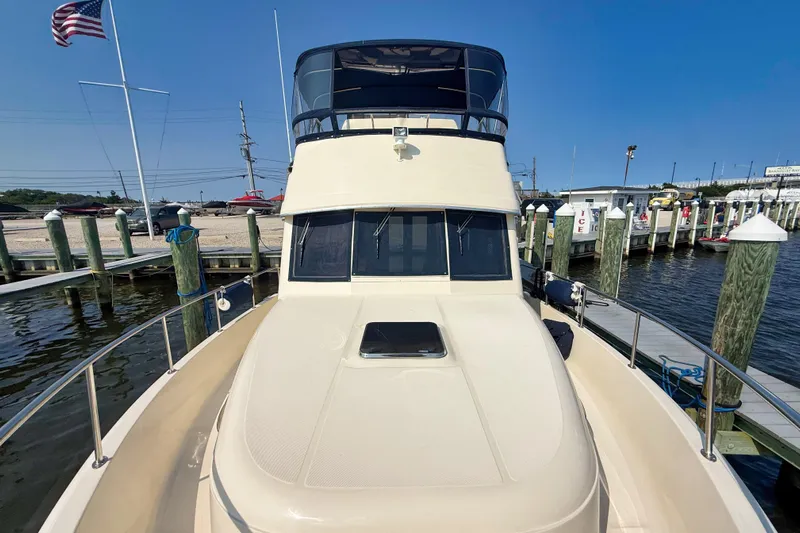  Yacht Photos Pics 2008 Mainship 34 Trawler docked at marina, clear sky, American flag visible.