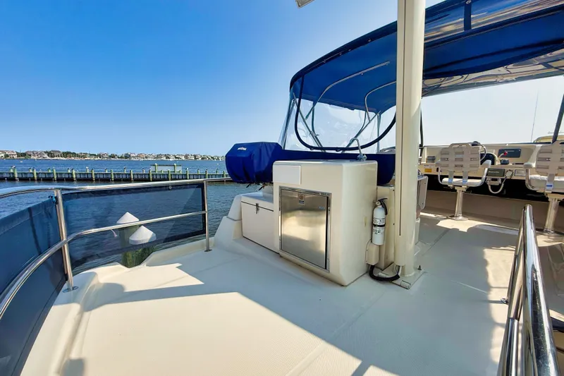  Yacht Photos Pics 2008 Mainship 34 Trawler deck with seating, blue canopy, and waterfront view.
