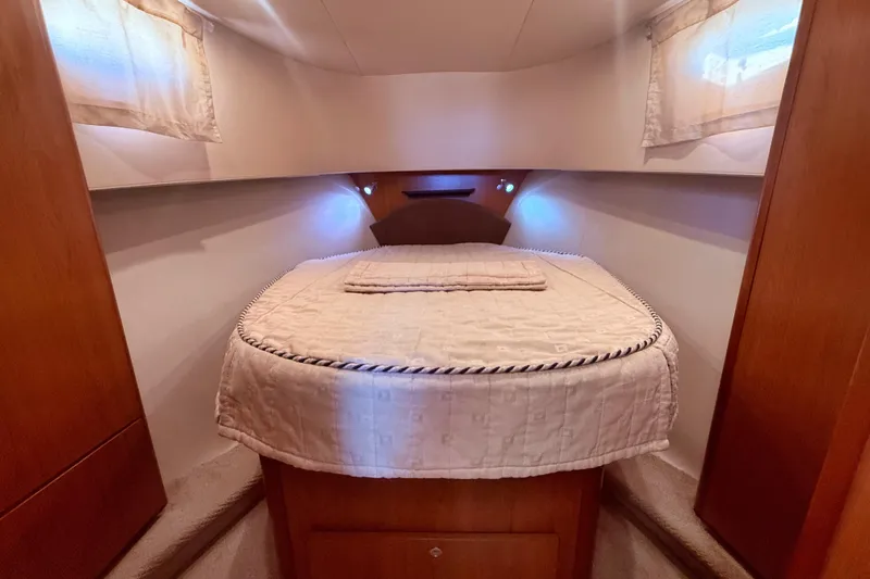  Yacht Photos Pics Cozy bedroom interior of 2008 Mainship 34 Trawler with elegant bedding and soft lighting.