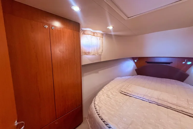  Yacht Photos Pics 2008 Mainship 34 Trawler cabin interior with bed and wooden wardrobe.