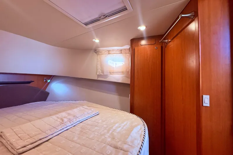  Yacht Photos Pics Cozy bedroom interior of 2008 Mainship 34 Trawler with wood paneling and soft lighting.