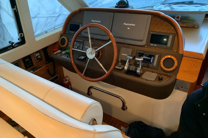  Yacht Photos Pics 2008 Mochi Craft 54' Dolphin yacht helm with Raymarine navigation system and wooden steering wheel.