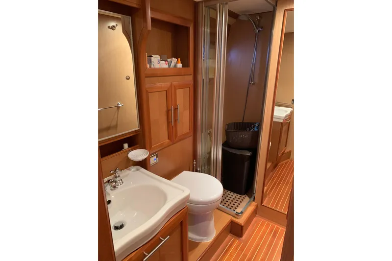  Yacht Photos Pics Luxurious bathroom in 2008 Mochi Craft 54' Dolphin yacht with wooden cabinetry and modern fixtures.