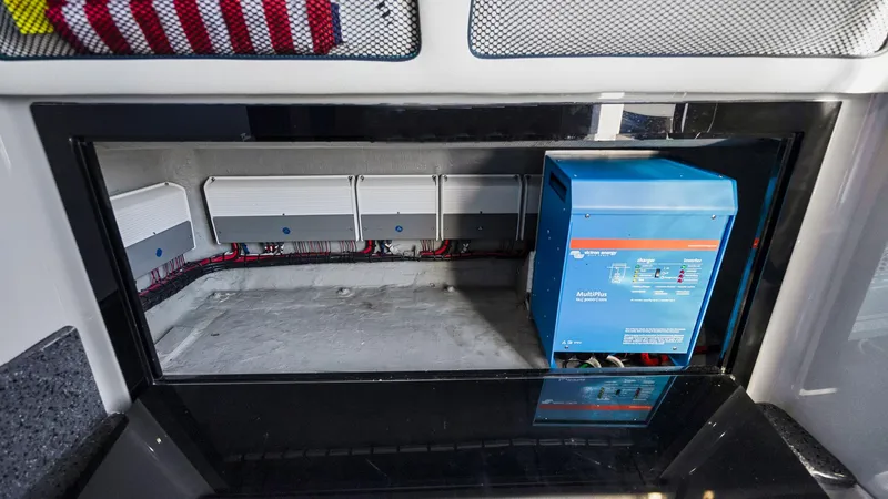  Yacht Photos Pics Electrical compartment of 2022 Deep Impact 399 Cabin boat, featuring wiring and a blue power unit.