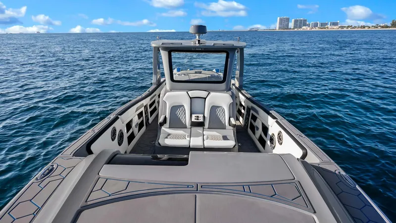  Yacht Photos Pics 2022 Deep Impact 399 Cabin boat on open water, clear sky, distant city skyline.