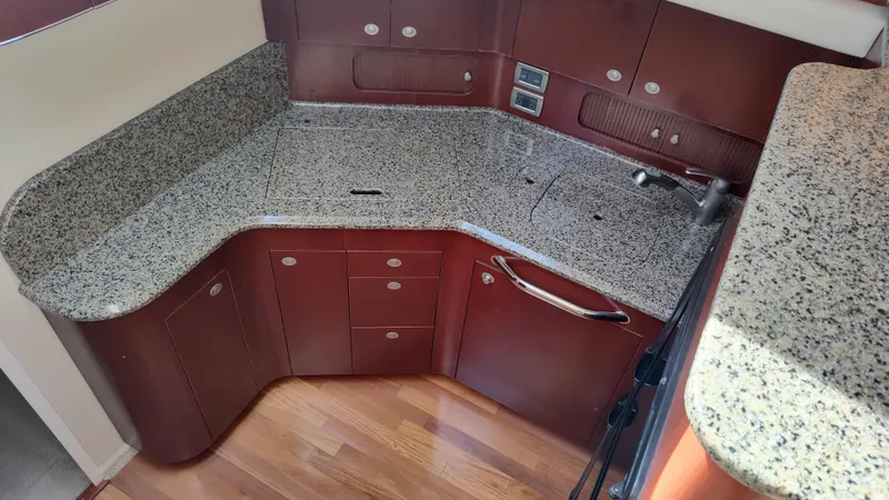 Drifter Yacht Photos Pics 2005 Sea Ray 390 Motor Yacht kitchen with granite countertops and wooden cabinets.