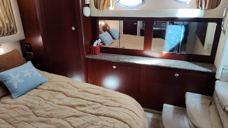 Drifter Yacht Photos Pics Luxurious bedroom interior of 2005 Sea Ray 390 Motor Yacht with cozy bedding and wooden cabinetry.