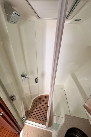 Headhunter Yacht Photos Pics Shower area in 2010 SeaVee 430 Sport Express boat, featuring glass door and wooden floor mat.