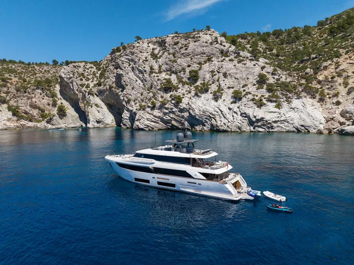 Mac One Yacht Photos Pics Luxurious 2019 Custom Line Navetta 33 yacht anchored near rocky coastline.