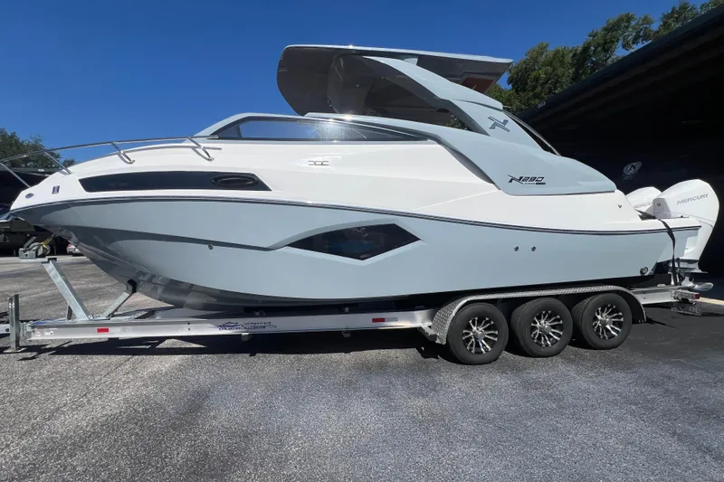 Yacht Photos Pics 2024 NX Boats 290 Exclusive on trailer, sleek design, parked outdoors.