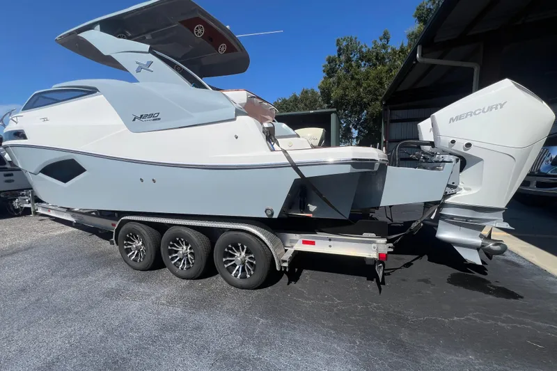  Yacht Photos Pics 2024 NX Boats 290 Exclusive on trailer, featuring sleek design and powerful Mercury outboard engine.