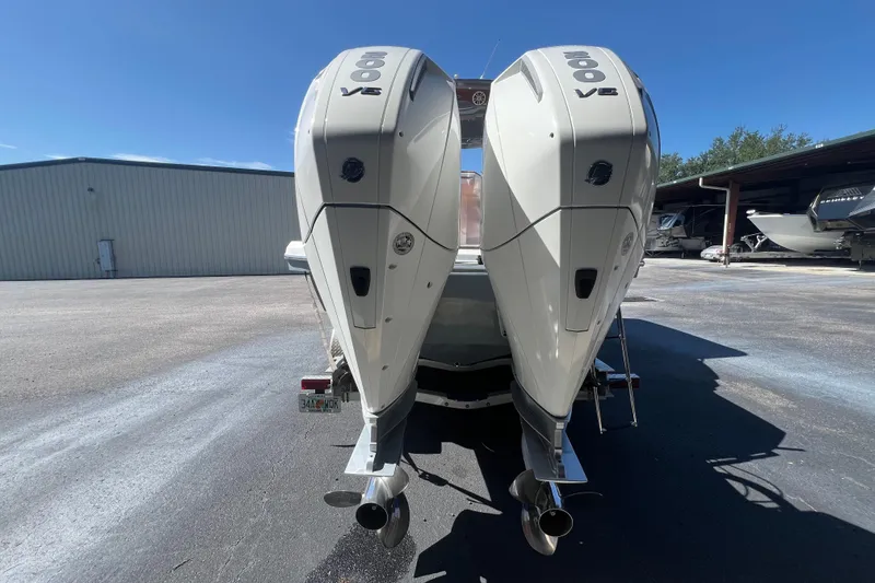  Yacht Photos Pics 2024 NX Boats 290 Exclusive with dual outboard engines in a marina setting.