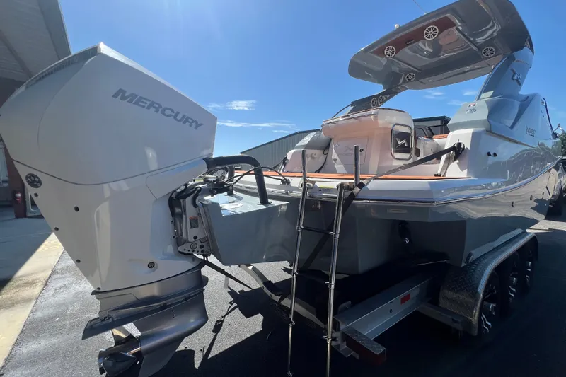  Yacht Photos Pics 2024 NX Boats 290 Exclusive with Mercury engine, rear view on trailer under clear sky.