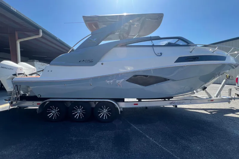  Yacht Photos Pics 2024 NX Boats 290 Exclusive on trailer, sleek design under bright sunlight.
