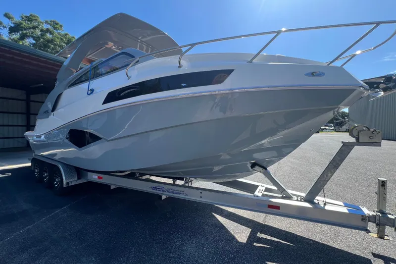  Yacht Photos Pics 2024 NX Boats 290 Exclusive on trailer, sleek design under sunny sky.