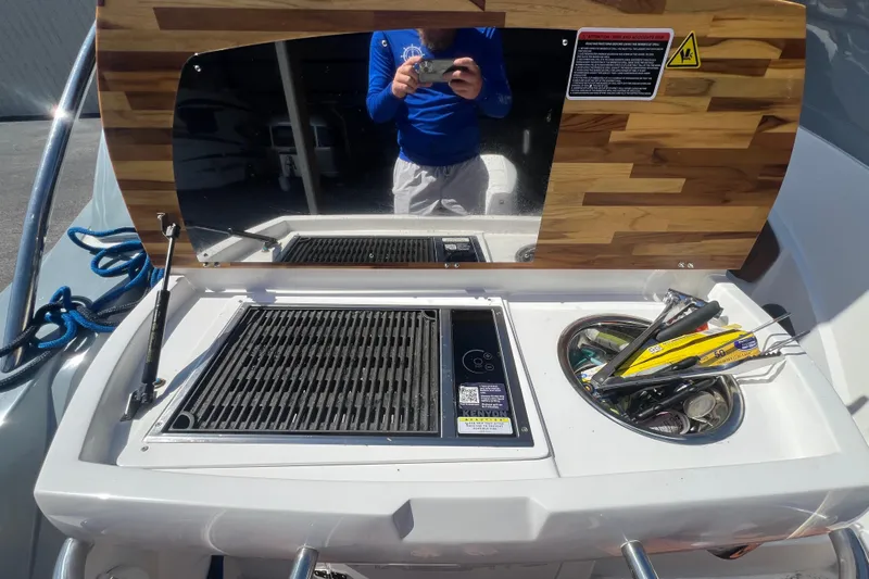  Yacht Photos Pics 2024 NX Boats 290 Exclusive grill station with wooden cover and utensils.