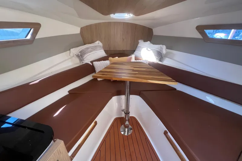  Yacht Photos Pics 2024 NX Boats 290 Exclusive cabin interior with brown seating and wooden table.