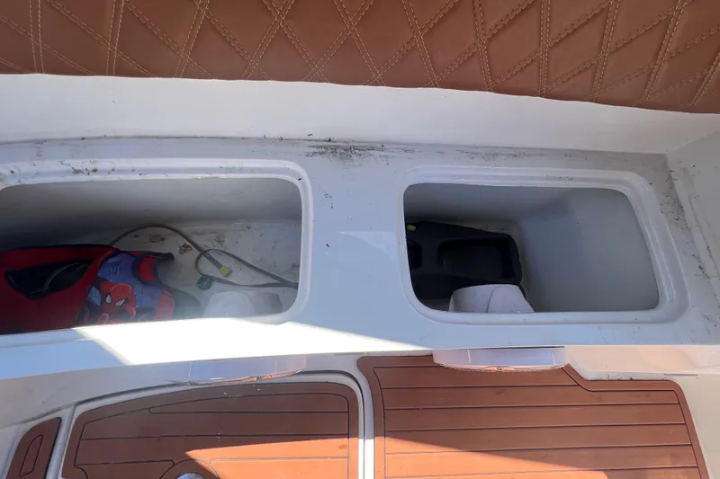  Yacht Photos Pics 2024 NX Boats 290 Exclusive storage compartments with brown leather seating and wooden flooring.