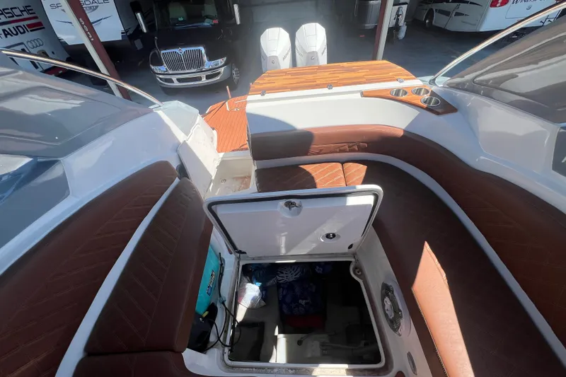  Yacht Photos Pics 2024 NX Boats 290 Exclusive interior with open storage compartment and brown seating.