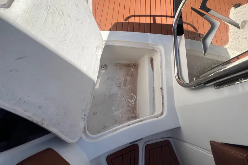  Yacht Photos Pics Open storage compartment on 2024 NX Boats 290 Exclusive, featuring teak flooring and stainless steel railing.