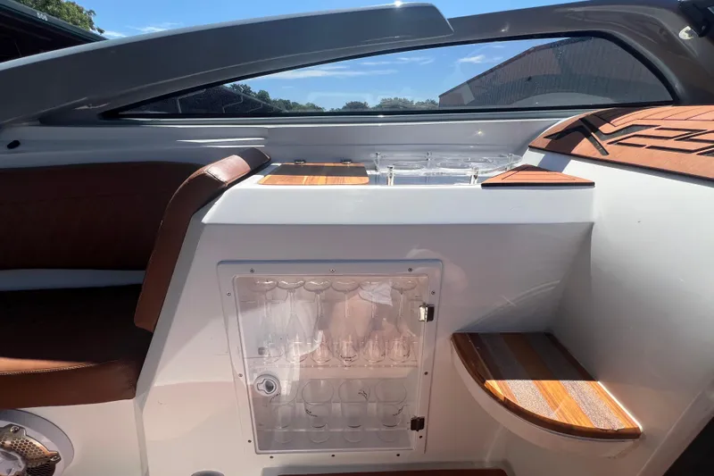  Yacht Photos Pics 2024 NX Boats 290 Exclusive interior with seating and storage under sunny sky.