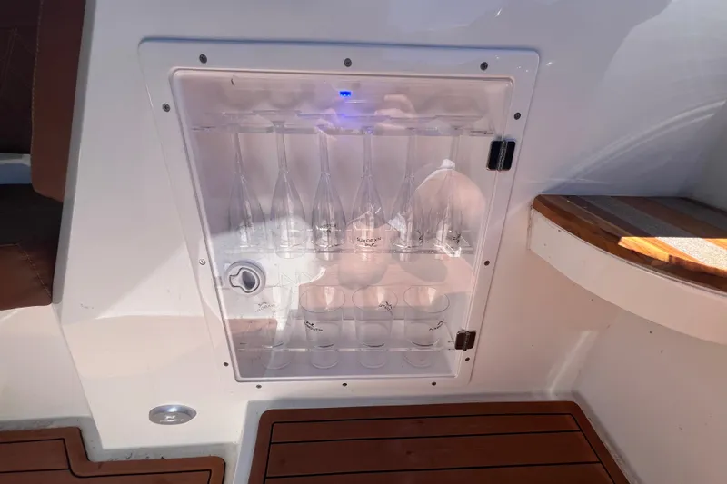  Yacht Photos Pics 2024 NX Boats 290 Exclusive glass storage compartment with elegant design and wooden flooring.