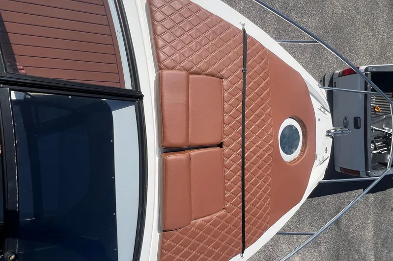  Yacht Photos Pics 2024 NX Boats 290 Exclusive with brown quilted deck cushions and circular window.