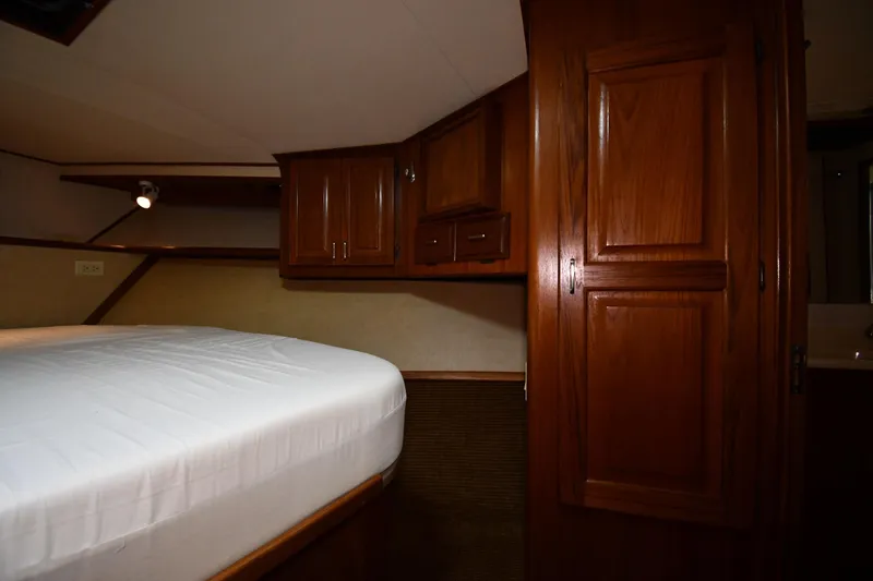 Patience III Yacht Photos Pics 1988 Viking 48 Convertible yacht interior with wooden cabinets and bed.