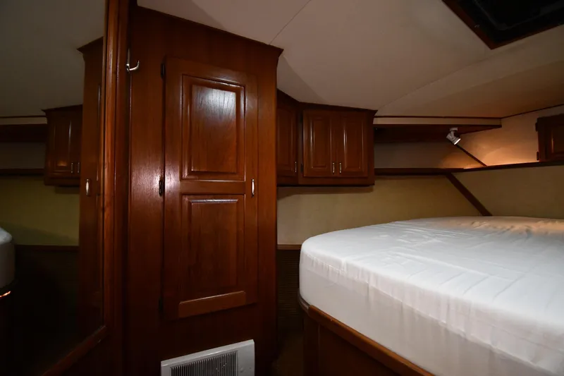 Patience III Yacht Photos Pics Interior cabin of 1988 Viking 48 Convertible yacht with wooden cabinetry and bed.