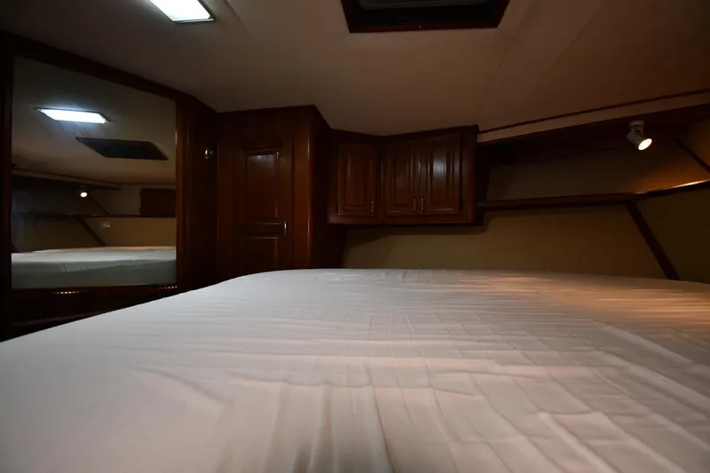 Patience III Yacht Photos Pics Interior cabin of 1988 Viking 48 Convertible yacht with wooden cabinets and bed.