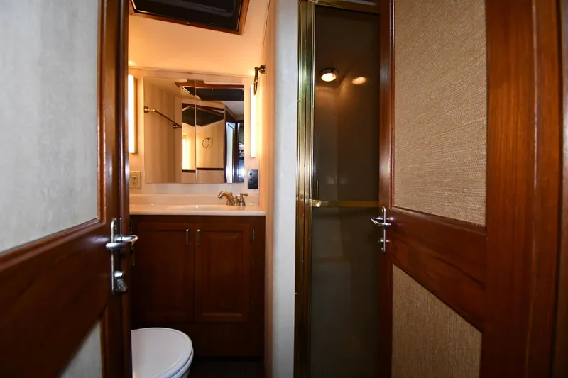 Patience III Yacht Photos Pics Bathroom interior of 1988 Viking 48 Convertible yacht with wooden cabinetry and shower.