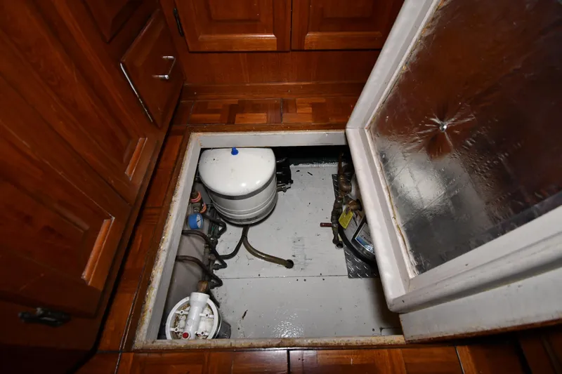 Patience III Yacht Photos Pics Engine compartment of 1988 Viking 48 Convertible boat with wooden flooring and equipment.