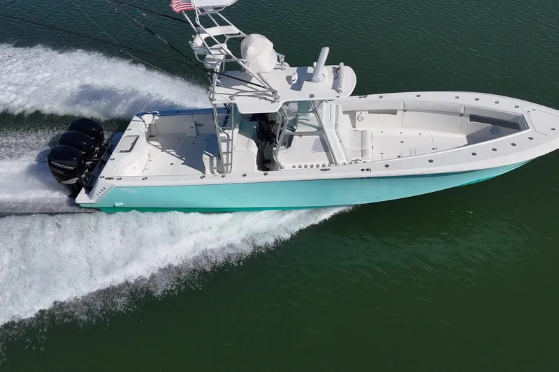Uno Mas Yacht Photos Pics 2013 SeaVee 39B Center Console boat cruising on water with triple outboard engines.