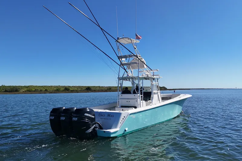 Uno Mas Yacht Photos Pics 2013 SeaVee 39B Center Console boat on calm water, equipped with triple Mercury engines.