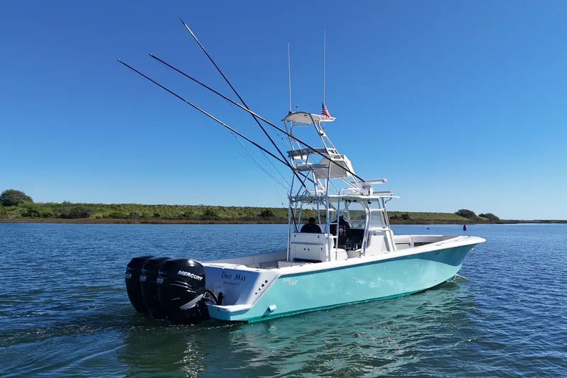 Uno Mas Yacht Photos Pics 2013 SeaVee 39B Center Console boat with triple Mercury engines on calm water.