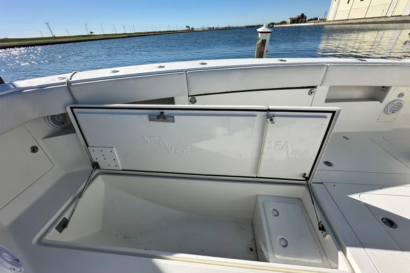 Uno Mas Yacht Photos Pics 2013 SeaVee 39B Center Console boat with open storage compartment by the water.