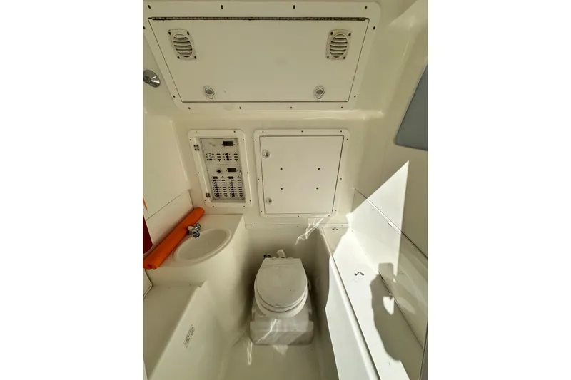 Uno Mas Yacht Photos Pics 2013 SeaVee 39B Center Console interior with toilet and control panel.